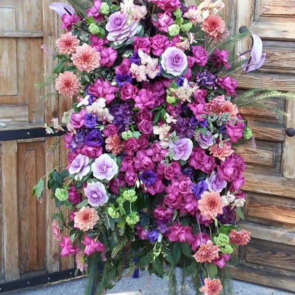 Tall floral spray with purple, pink, and peach blooms