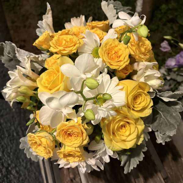 Bouquet of yellow roses and white daisies with silvery foliage
