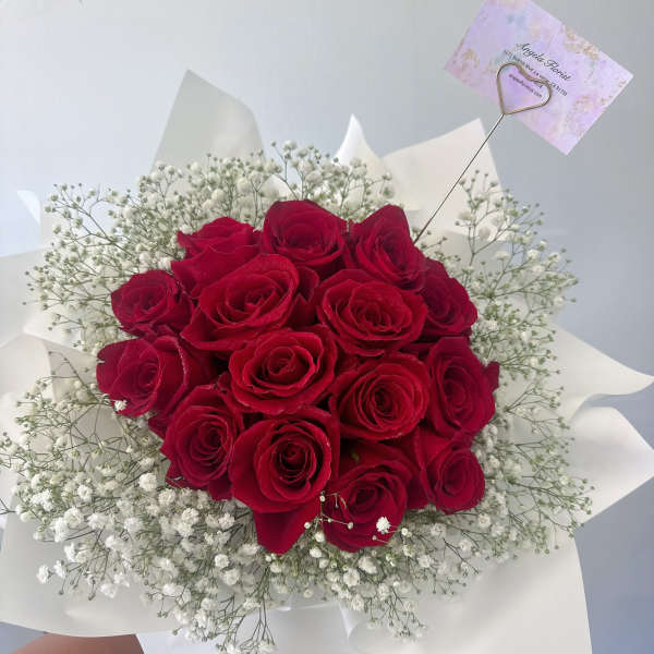 Bouquet of red roses with white baby's breath in white wrap