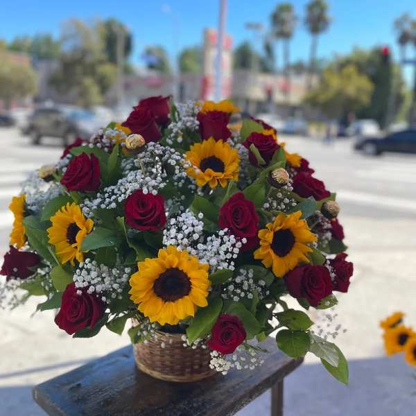 Basket arrangement of red roses and yellow sunflowers