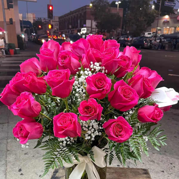 Hot pink roses in a glass vase with white baby's breath