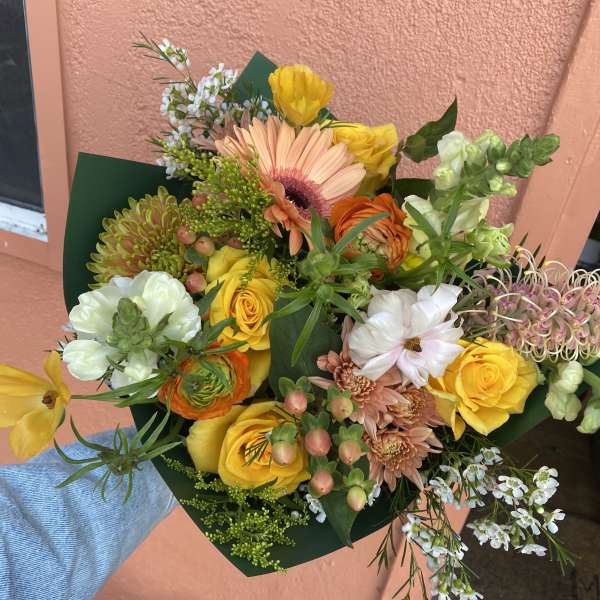Hand-tied bouquet of yellow, peach, and white mixed flowers