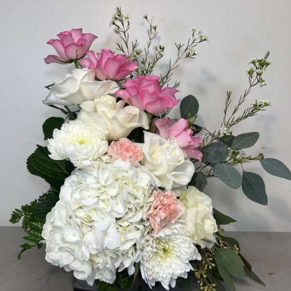 Pink and white floral arrangement with roses, hydrangeas, and chrysanthemums
