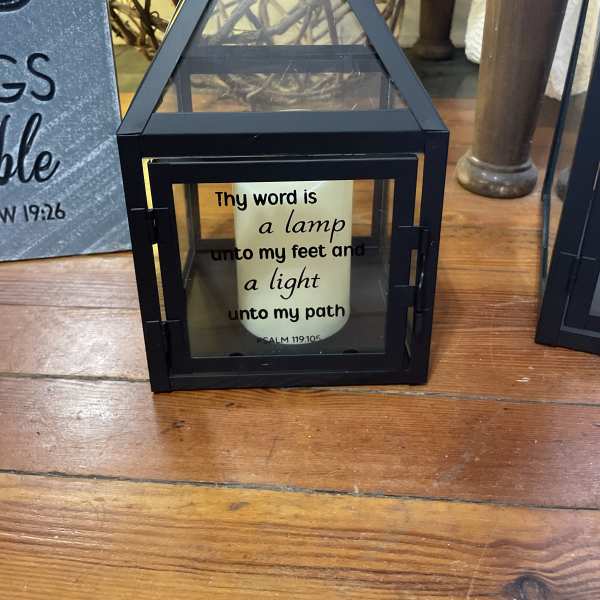 Black lantern with a candle and Bible verse text inside