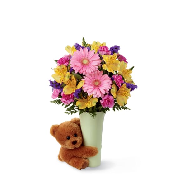 Pink and yellow mixed bouquet in a vase with a teddy bear