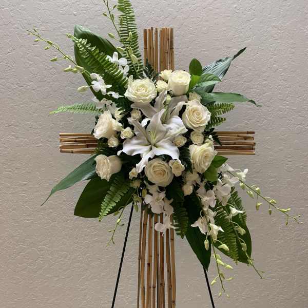 White floral arrangement on a bamboo cross stand