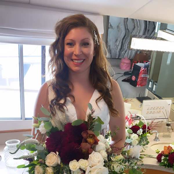 Bride holding a large bouquet of white and burgundy flowers