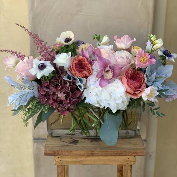 Mixed bouquet of pink, white, and purple flowers in a glass vase
