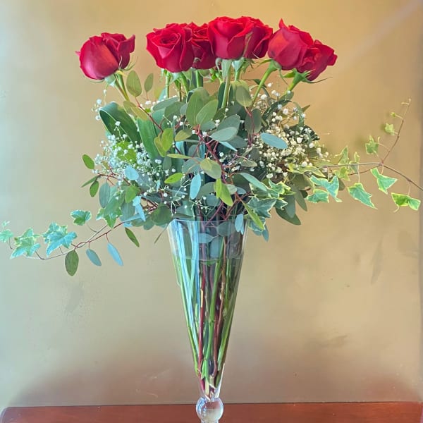 Tall bouquet of red roses in a clear glass vase
