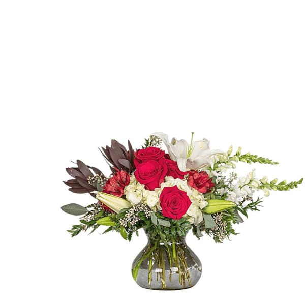 Bouquet of red roses and white lilies in a glass vase