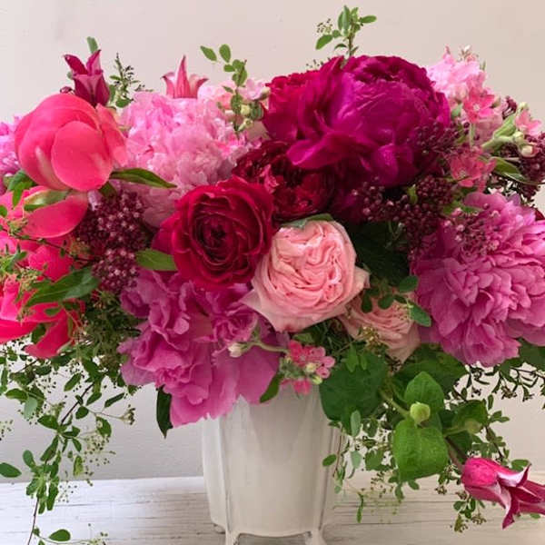 Pink and magenta floral arrangement in a white vase