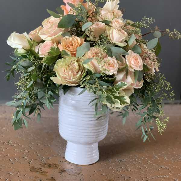 Peach and cream rose bouquet in a white vase