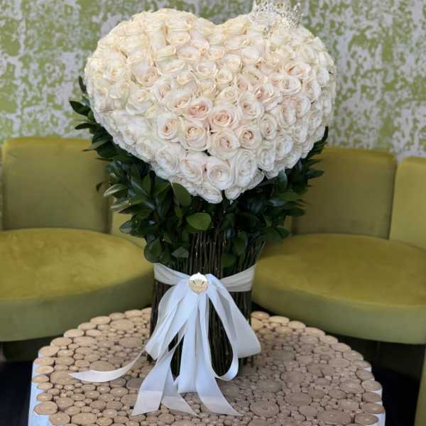 Heart-shaped bouquet of white roses with a white ribbon
