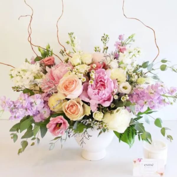 Pastel bouquet of roses, peonies, and lilac in a white vase