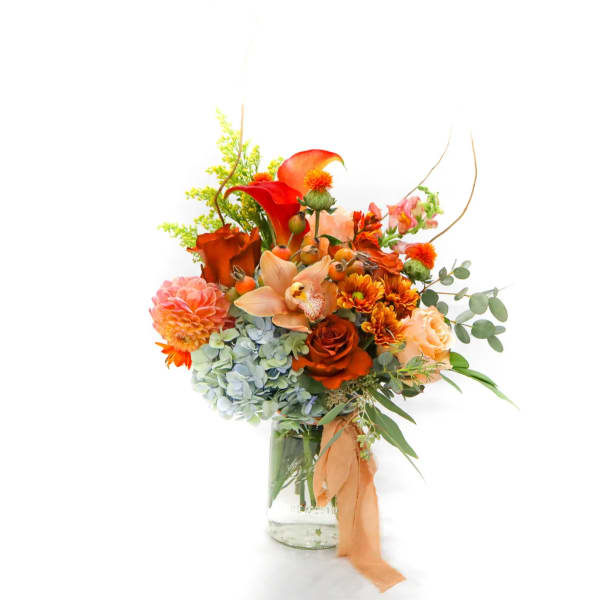 Orange and peach mixed bouquet in a glass vase