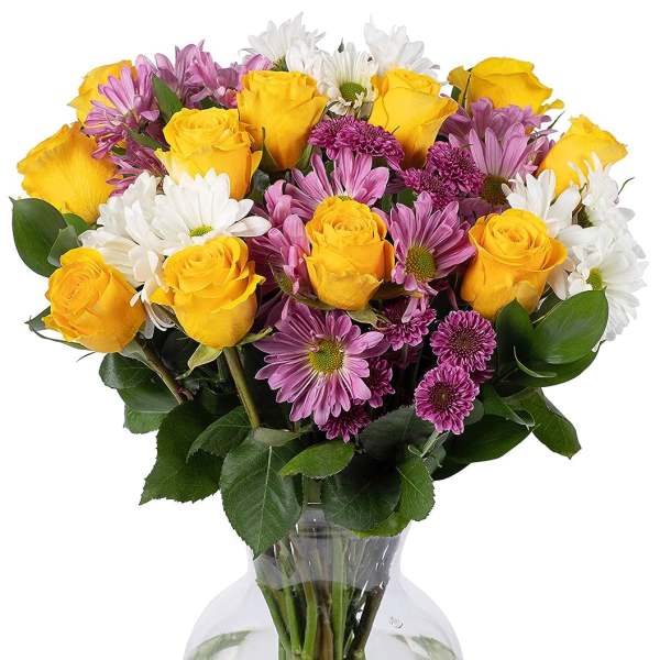Yellow roses with purple and white daisies arranged in a clear glass vase