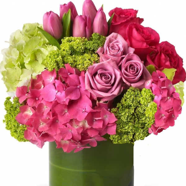 Pink and red roses with hydrangeas in a green glass vase
