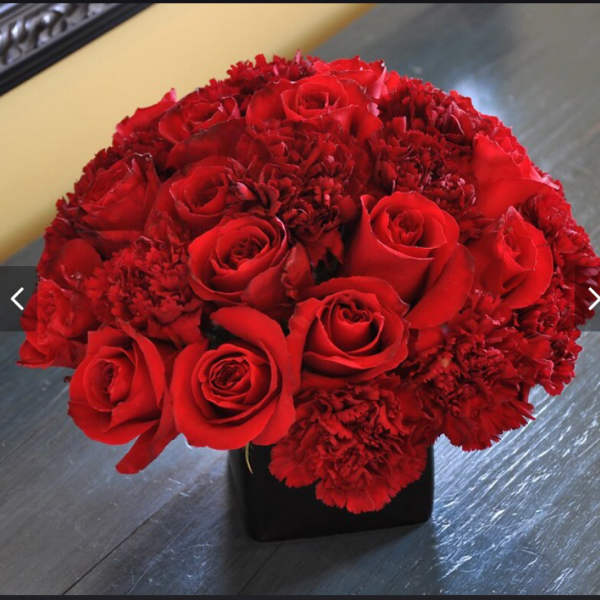 Red rose and carnation bouquet in a black vase
