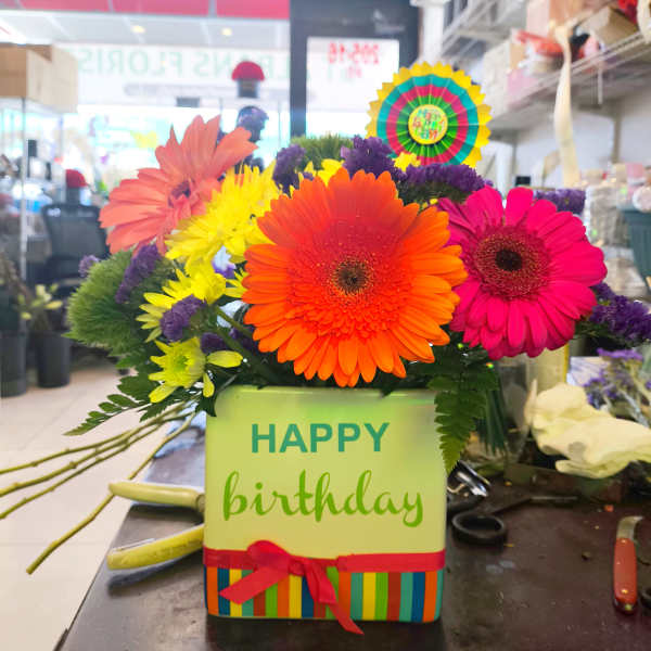 Bright gerbera daisy arrangement in a birthday gift box