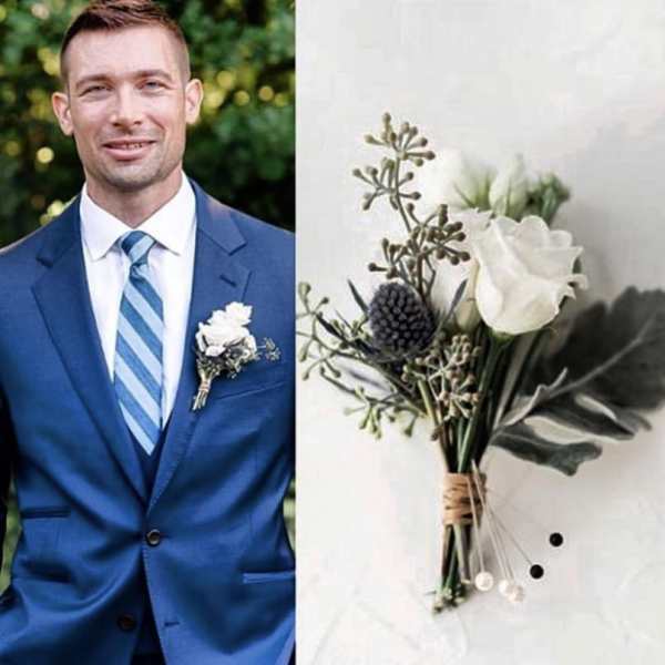 White boutonniere with greenery on a blue suit lapel