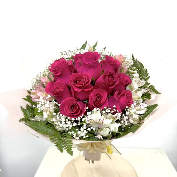 Bouquet of hot pink roses with white accent flowers