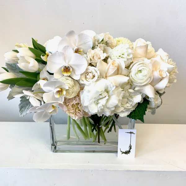 White floral arrangement in a clear rectangular vase
