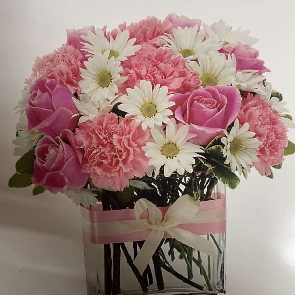 Pink roses and carnations with white daisies in a clear glass vase