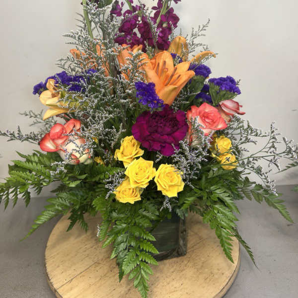Colorful mixed bouquet in a square glass vase