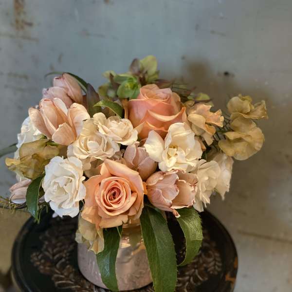 Peach and white roses arranged in a low vase