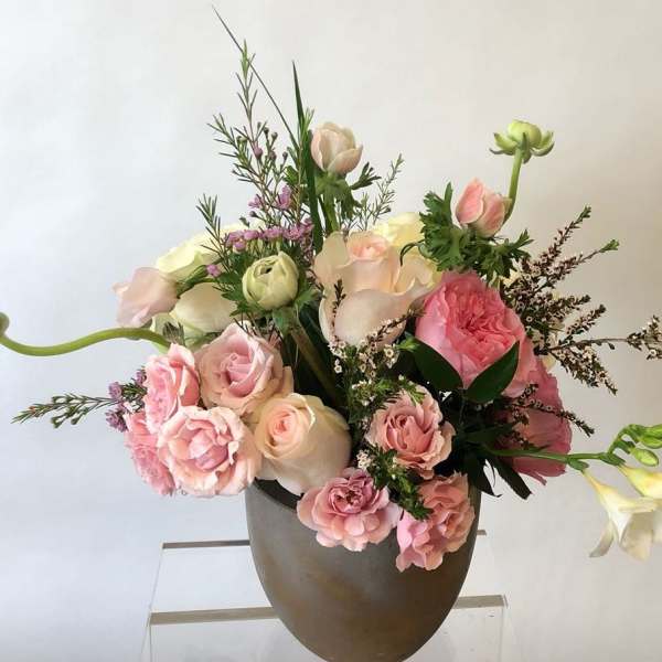 Pink and white floral arrangement in a brown vase
