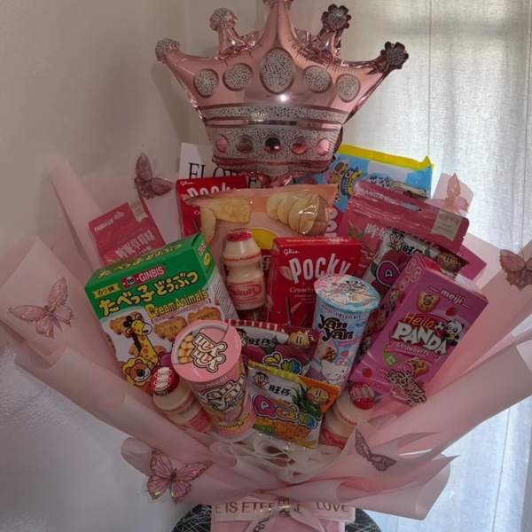 Pink gift bouquet with snacks, candy, and a crown balloon