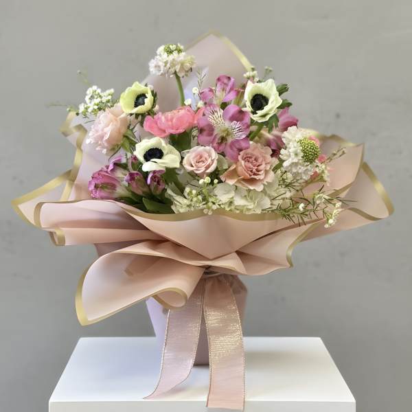 Bouquet of pink and white flowers wrapped in blush paper