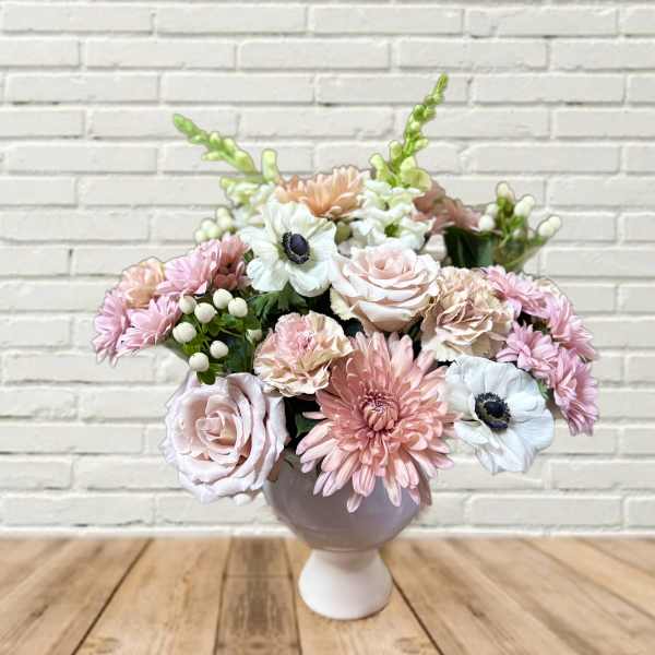 Pink and white flower arrangement in a round vase