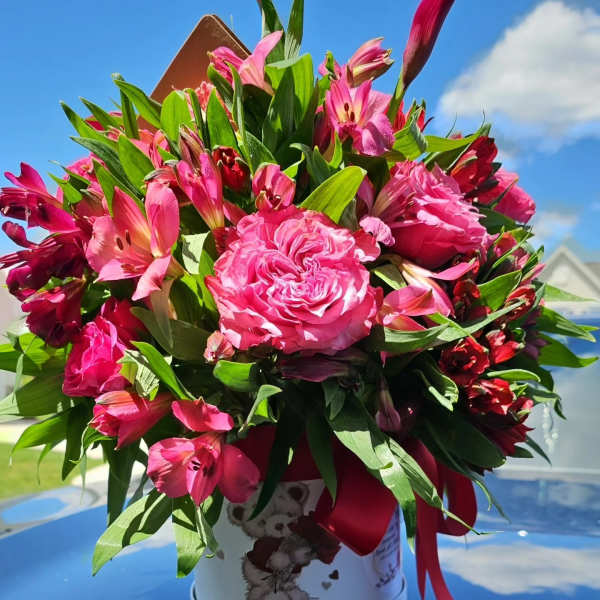 Pink bouquet with roses and alstroemeria in a white hatbox