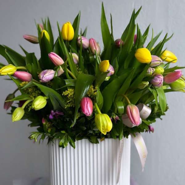 Mixed tulip bouquet in a white ribbed vase