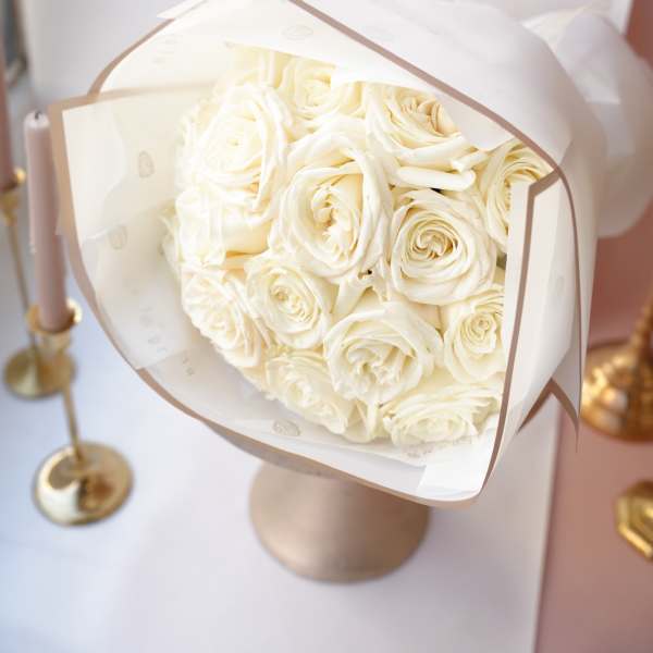 Bouquet of cream roses wrapped in white paper