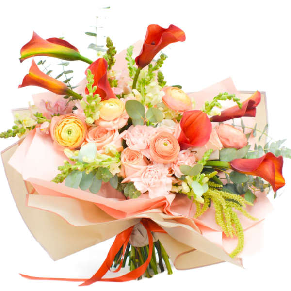Bouquet of orange calla lilies and peach roses wrapped in pink paper