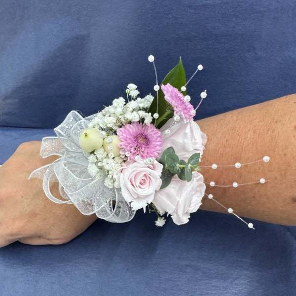 Pink and white wrist corsage with ribbon and pearl accents