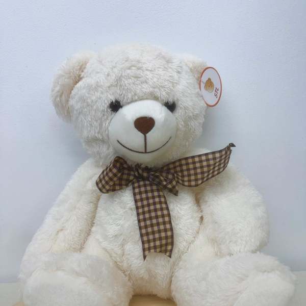 White teddy bear with a brown plaid ribbon bow