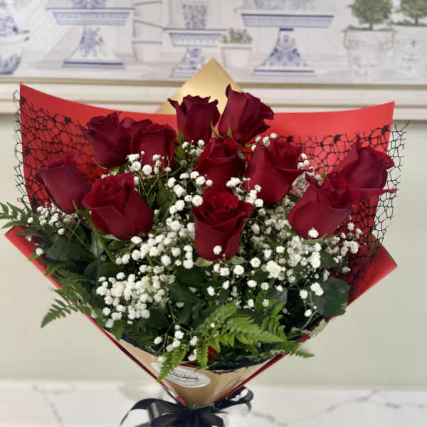 Bouquet of red roses and white baby's breath in a glass vase