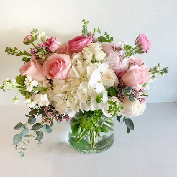 Pink and white rose bouquet in a clear glass vase