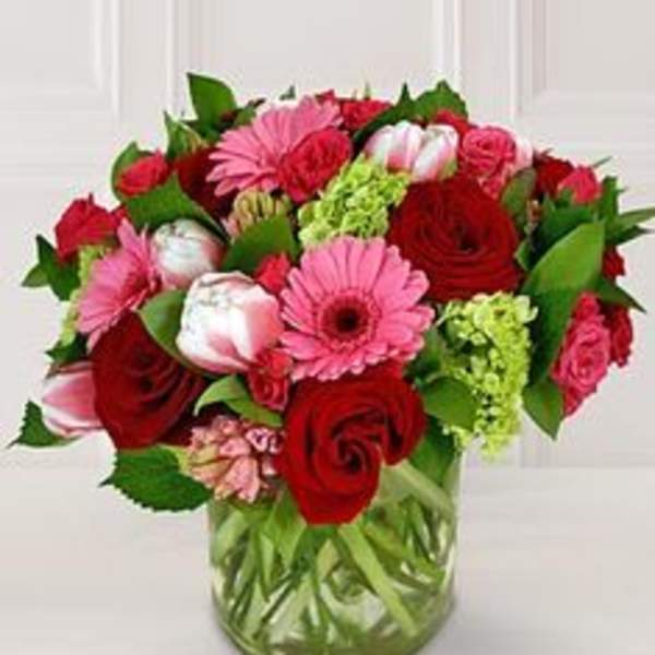 Bouquet of red and pink flowers in a clear glass vase