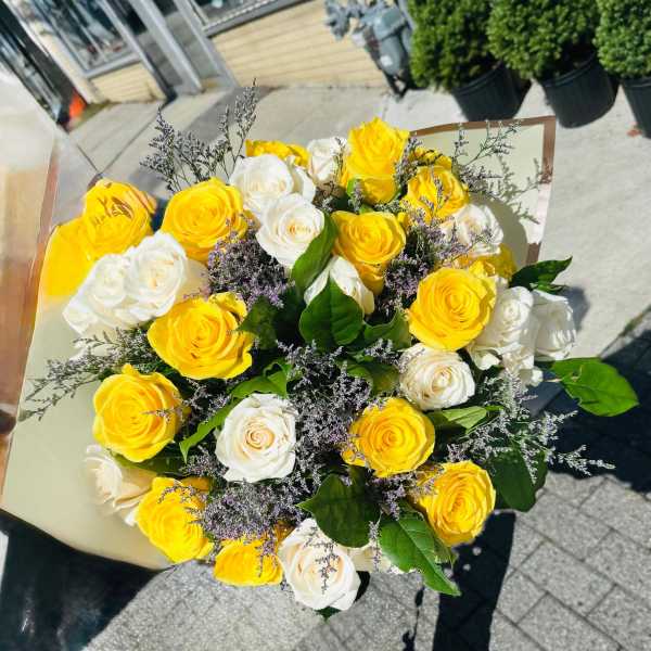 Bouquet of yellow and white roses with purple filler flowers