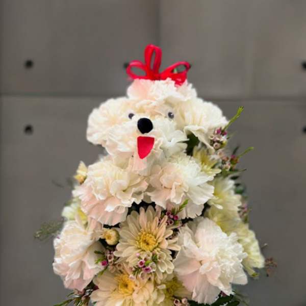 White flower arrangement shaped like a teddy bear with a red bow