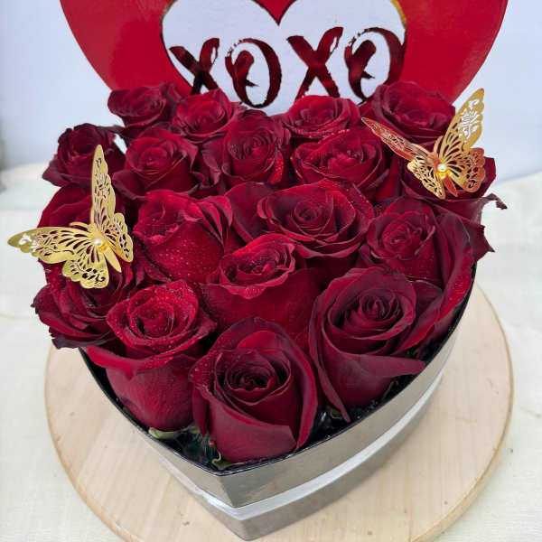 Heart-shaped box of red roses with butterfly decorations
