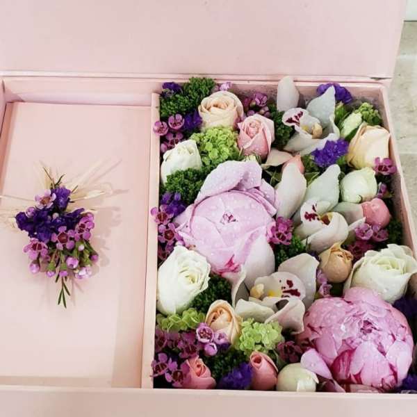 Pink gift box with a floral arrangement and matching boutonniere