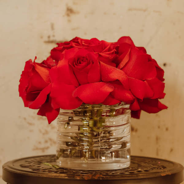Red roses arranged in a clear glass vase