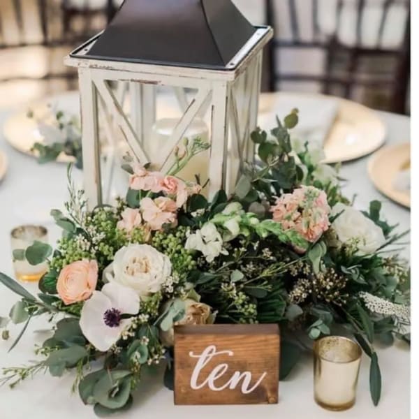 Wedding table centerpiece with a lantern and pastel flowers