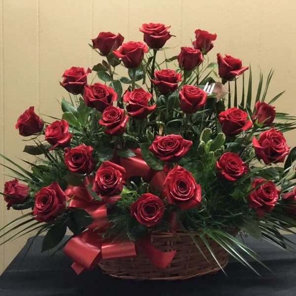 Basket arrangement of red roses with a red ribbon