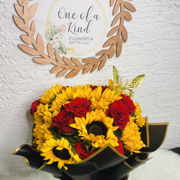 Bouquet of yellow sunflowers and red roses wrapped in black paper